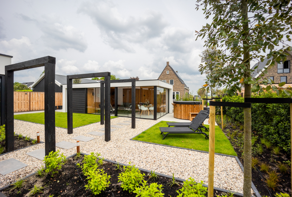 Tuin met gras, staptegels en een overkapping met glas