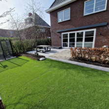 Tuin met gras, tegels en een tafel