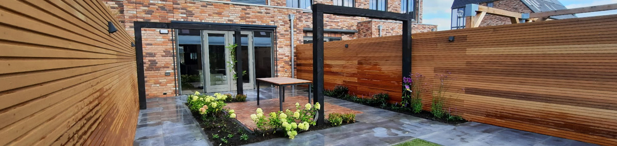 Tuin met houten schutting en tegels