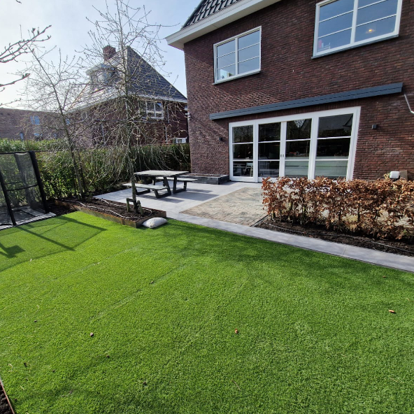 Tuin met kunstgras en bestrating
