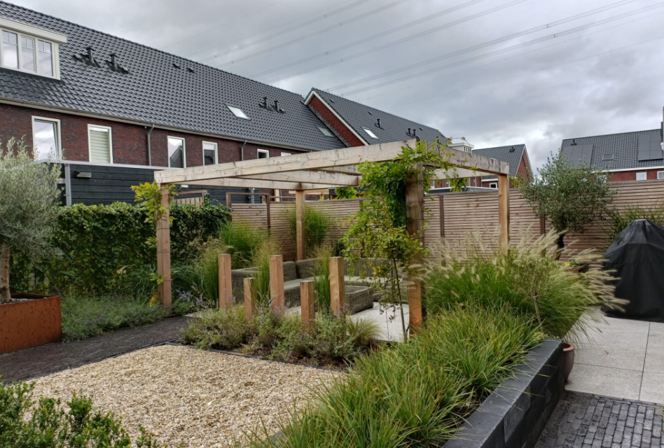 Tuin met veel groen en een zitplek